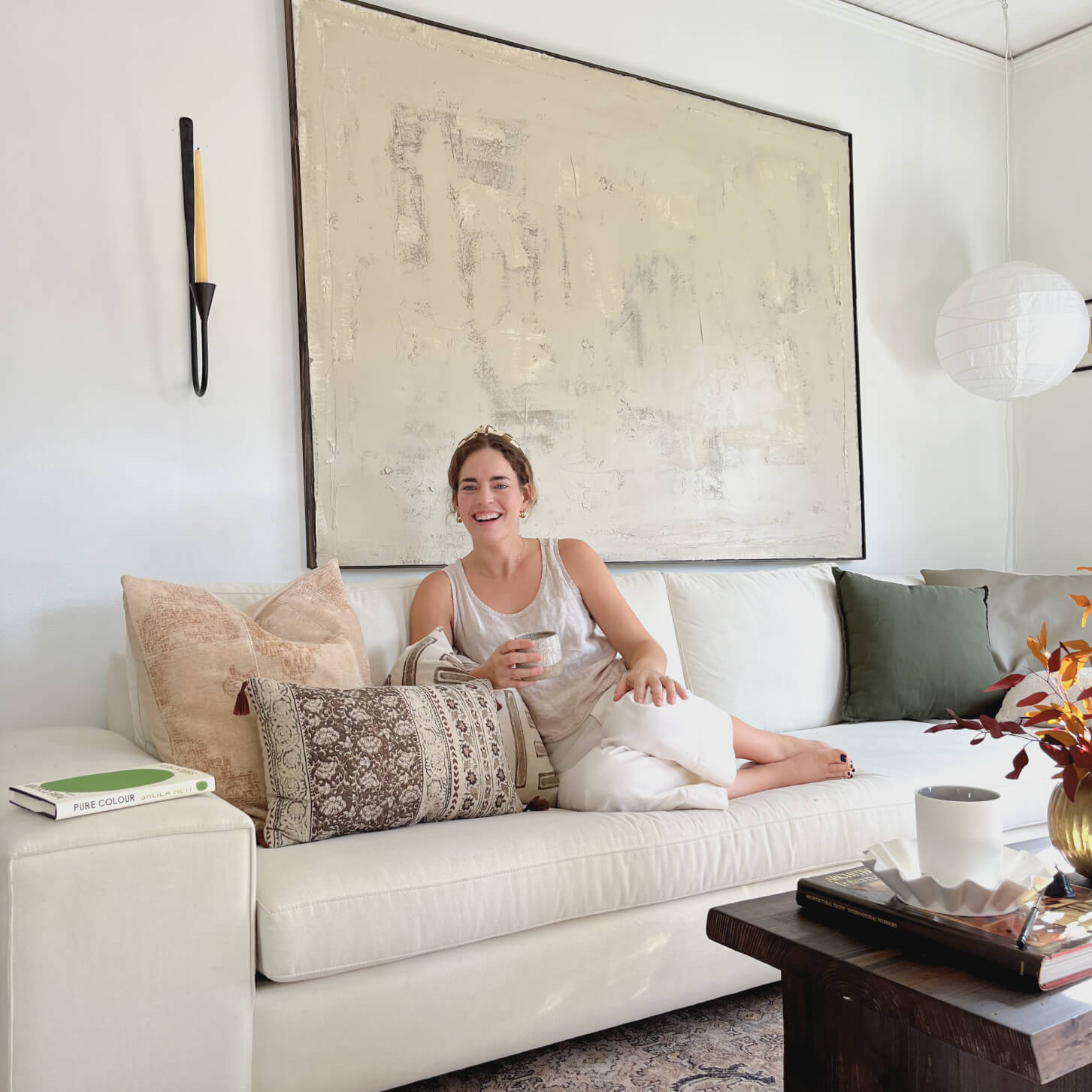Woman sitting on cream colored Natural latex + wool Blumen Sectional