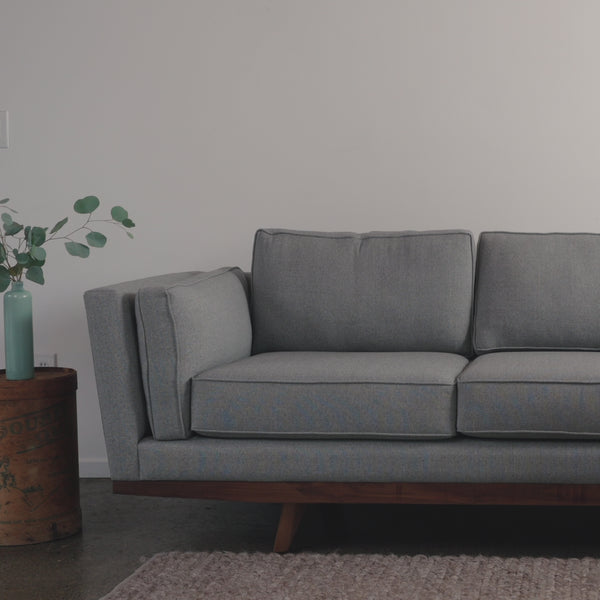 woman sits on grey kirnik sofa