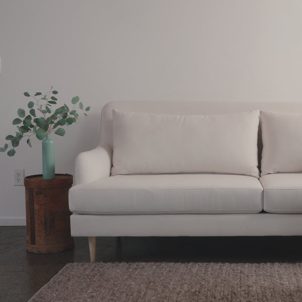 woman sits on white kaydan sofa
