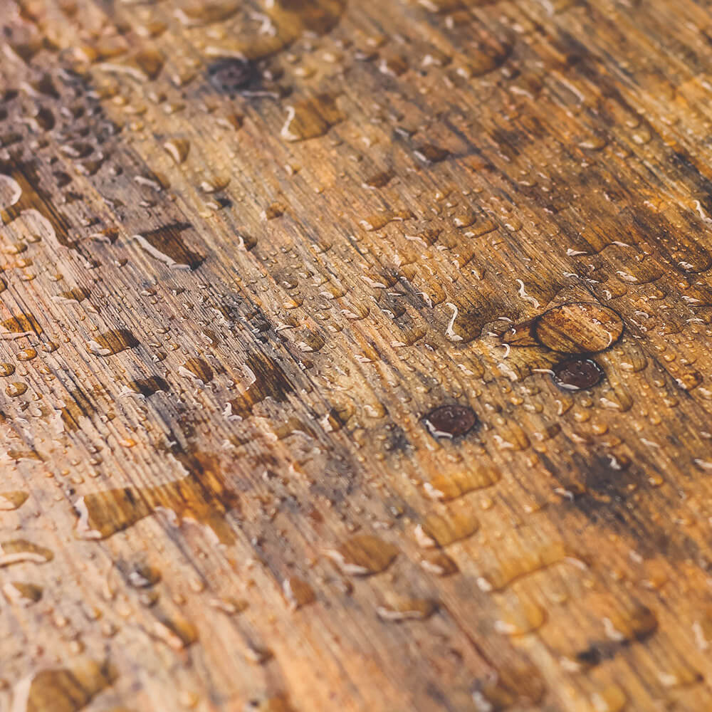Water droplets bead up on top of our solid wood