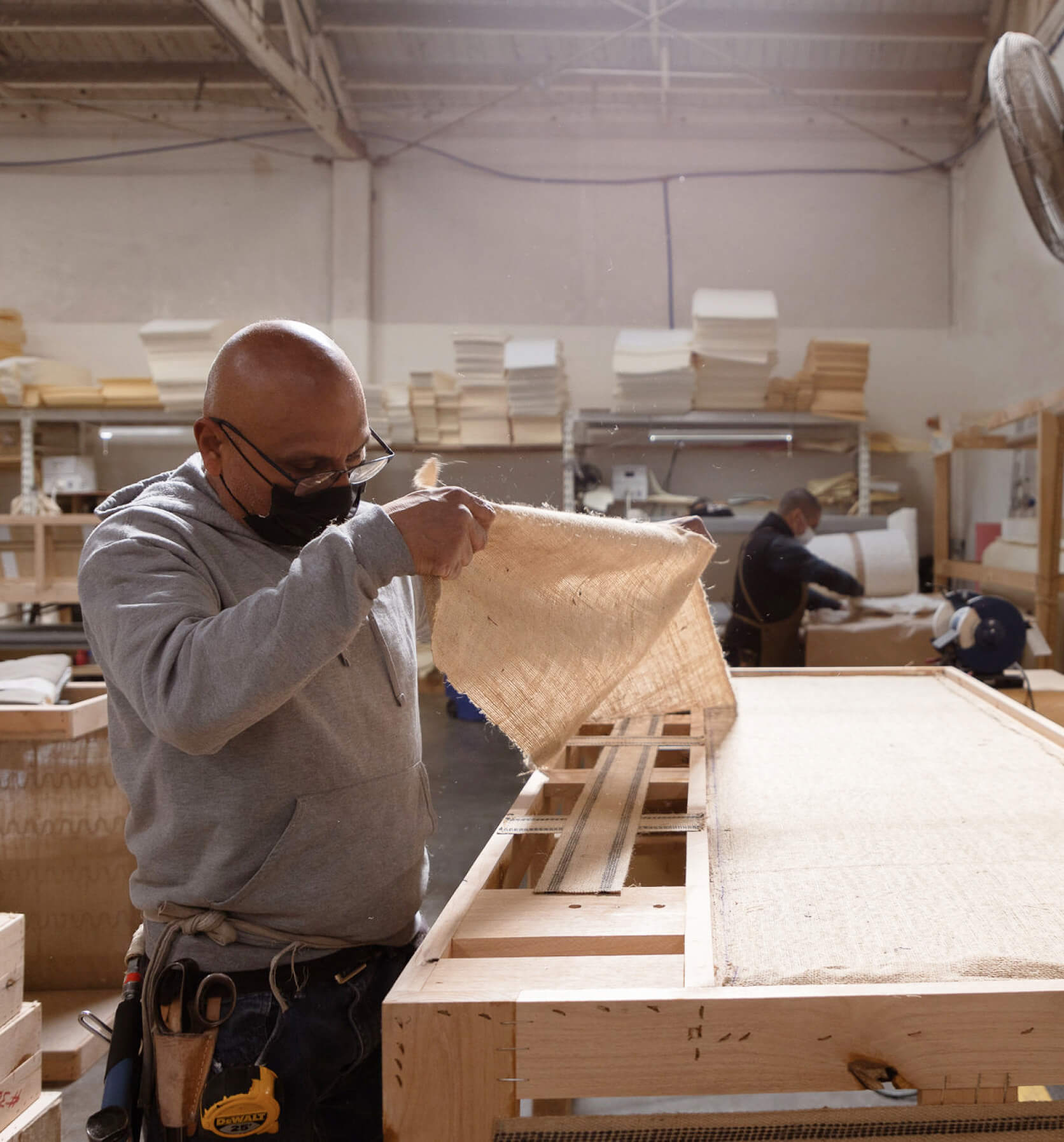 worker applying jute to a frame