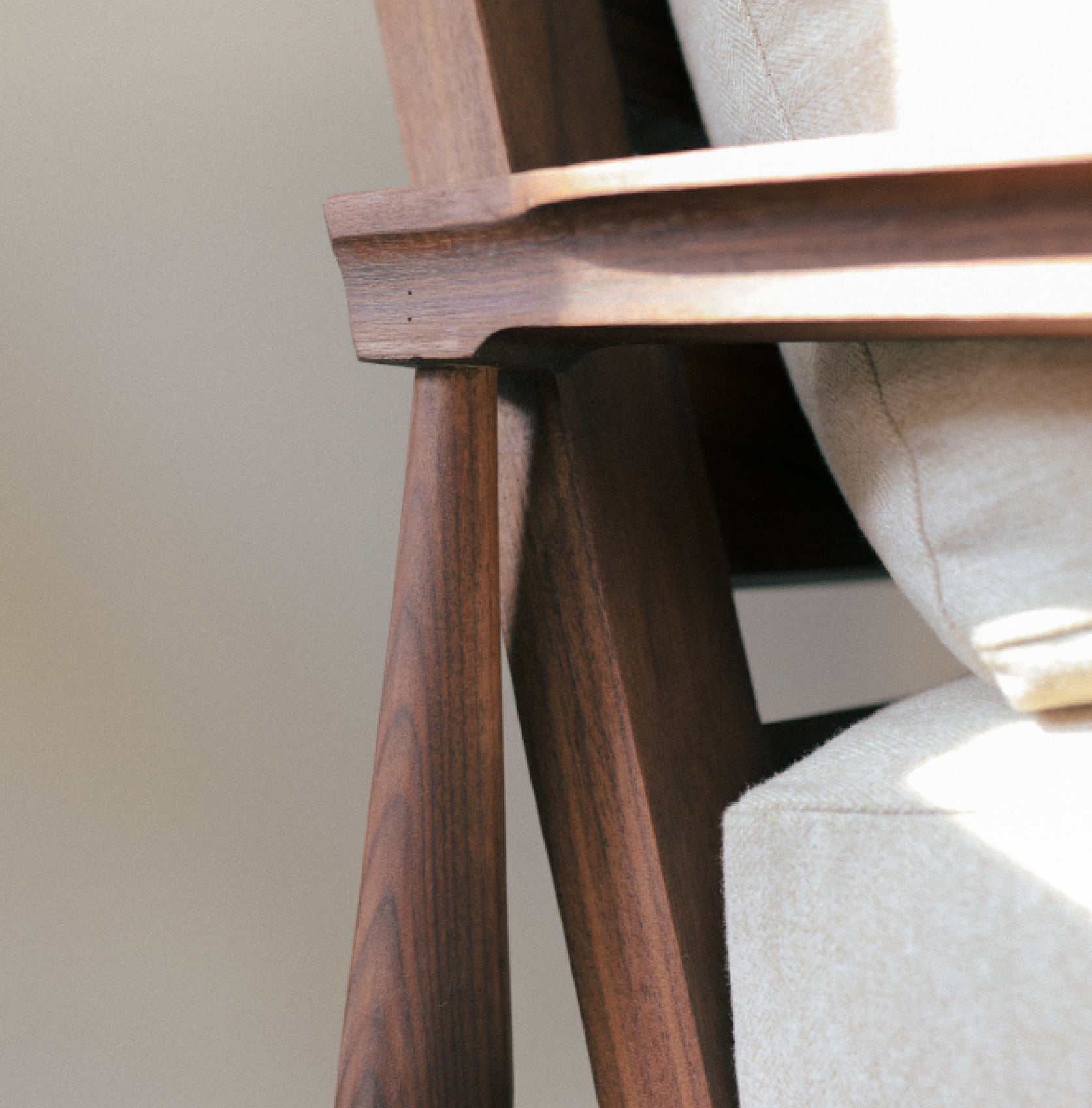 closeup of arm of walnut eim chair