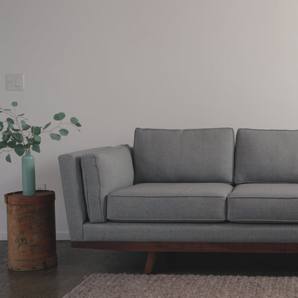 man sits on grey kirnik sofa
