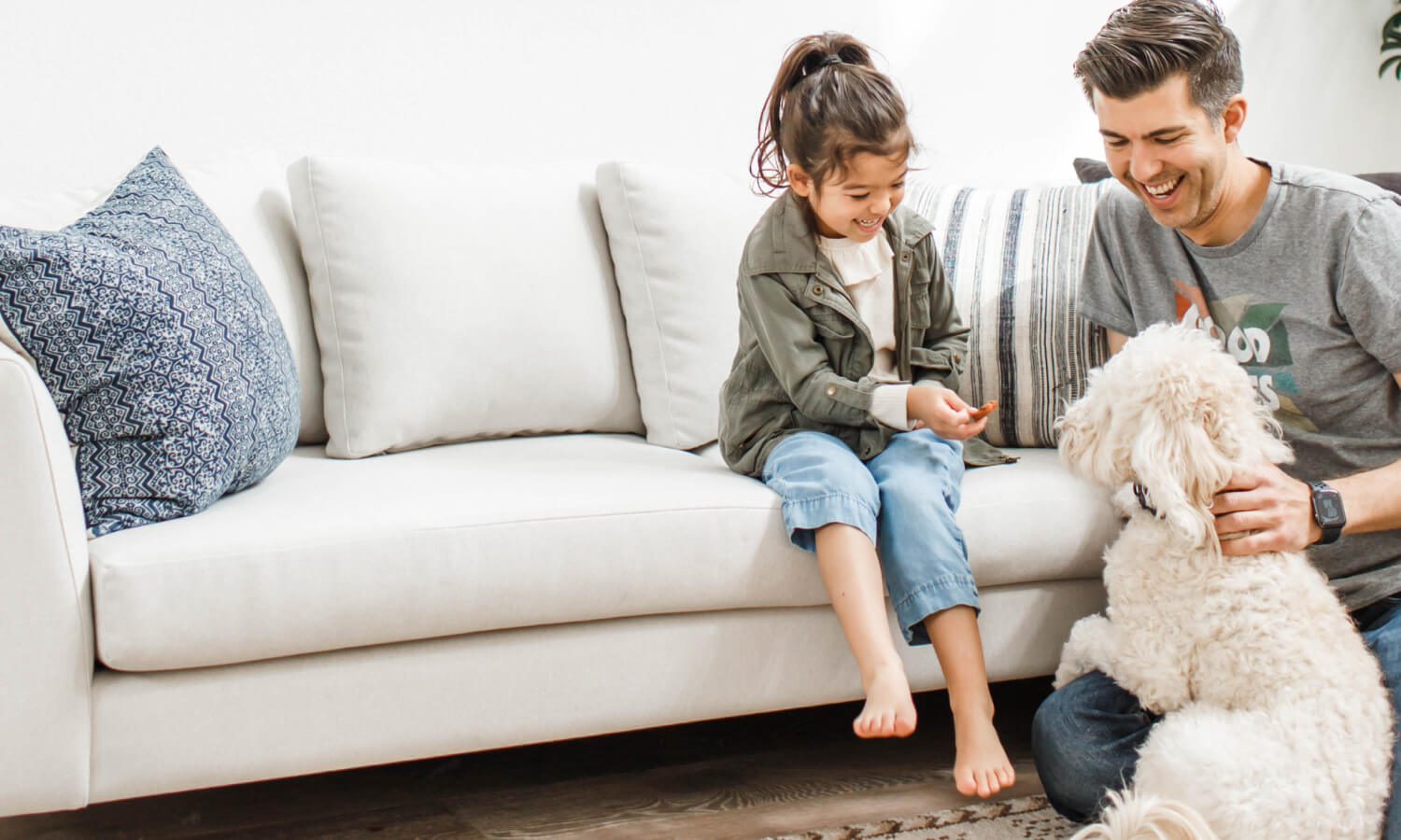 IRL: Daughter and father with white dog on white dekayess sofa