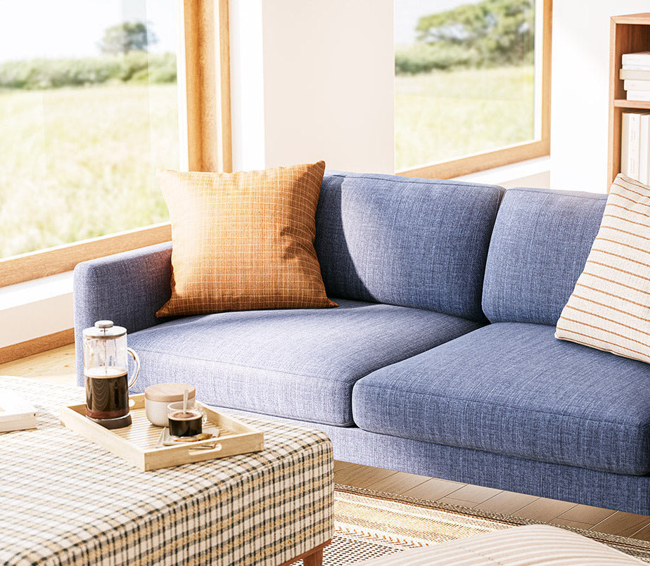 Shown in Smart Navy fabric with the Noah Ottoman in Arya, and Lulu Throw Pillows